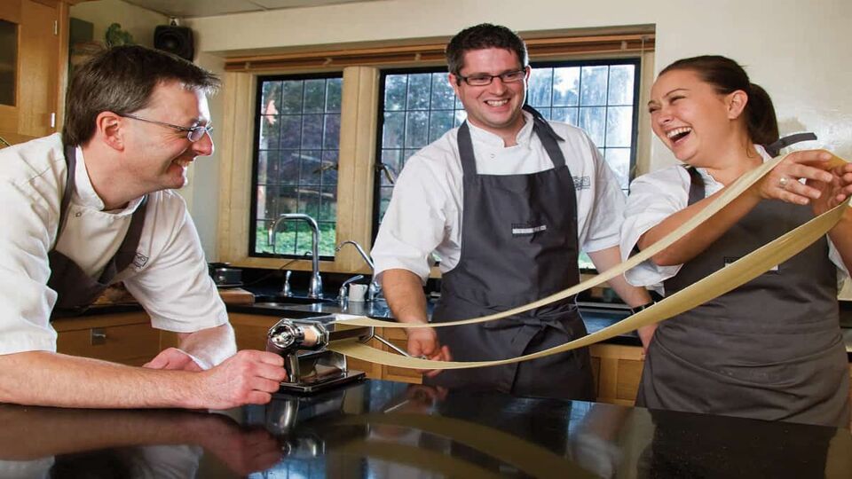 Three poeple making pasta in Raymond Blanc's cooking school