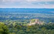 An elevated view of Highclere Castle taken from Beacon Hill. The castle can be seen peeking through the never ending woodlands