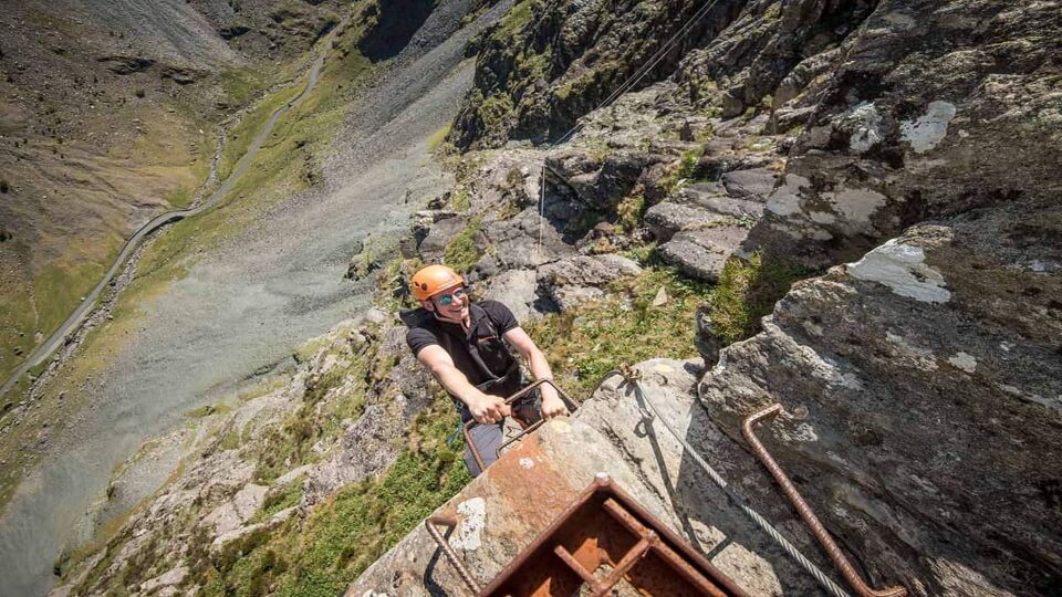 Man smiling as he descends iron ladder