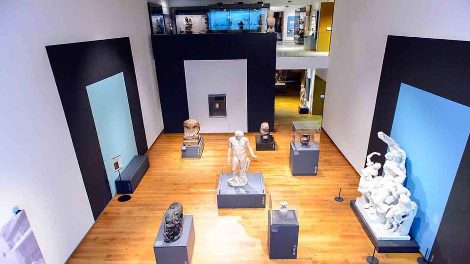 A view from above of several white marble statues of figures inside the museum