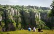 two people in a field staring at Cheddar Gorge