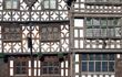 A close up of a Tutor building facade at Stratford upon Avon. The brown timber contracts heavily against the white building, drawing focus to the horizontal pattern on the exterior