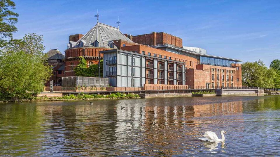 view of the river with the theatre on the riverbank at The Royal Shakespeare Theatre