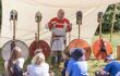 An Anglo-saxon history lesson, where children are sat down learning about the history with Anglo-saxon helmets and armour on display