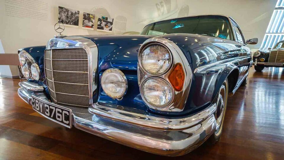A close up view of a classic blue Mercedes Benz bumper and headlights