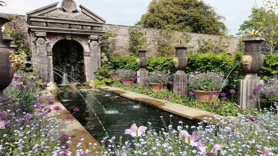 Inside view of the Gardens at Arundel Castle. A small rectangle fountain surrounded by a variety of flowers