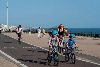 Woman with two kids cycling on the promenade