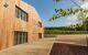 external view of the wooden tasting room with vineyard behind