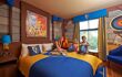 An inside view of Legoland Castle Hotel room, where the bed has bright yellow and blue bed sheet. Alongside the distinct blue, red and yellow accent designs around the room