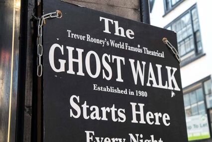 Sign advertising the start of a ghost walk visitor tourist attraction