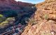 A group of visitors hiking in the canyon looking out from a wooden staircase halfway down the gorge