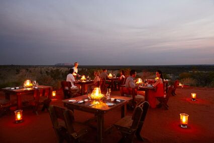 Tables in candlelight at sunset in the desert.