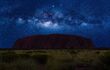 The silhouette of a wide flat mountain, under a sky with lots of stars.
