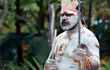 An aboriginal male warrior covered in white paint.