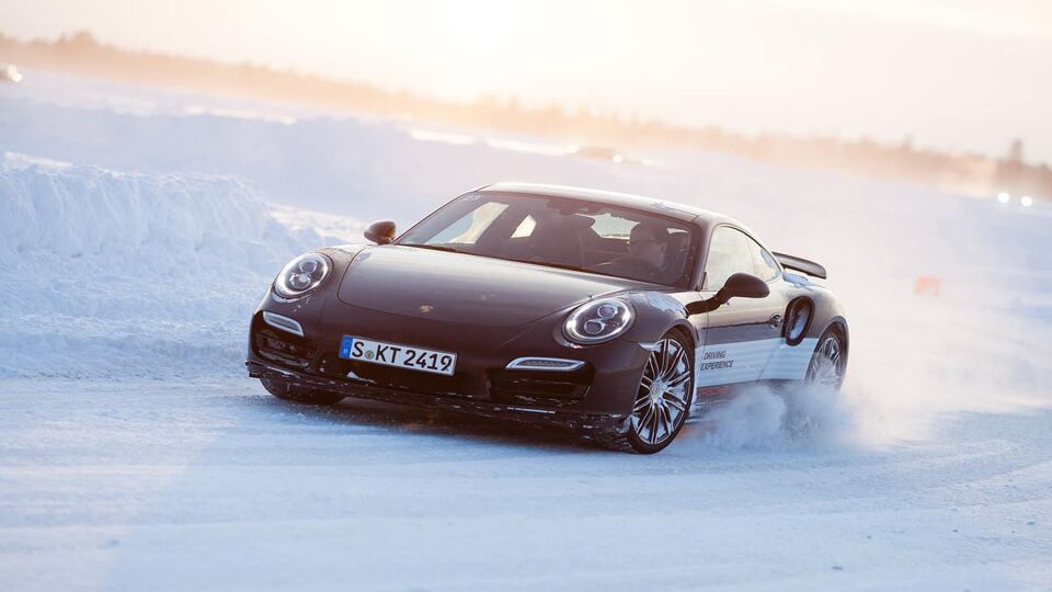 Close up of a black Porsche skidding on the ice circuit at Tignes