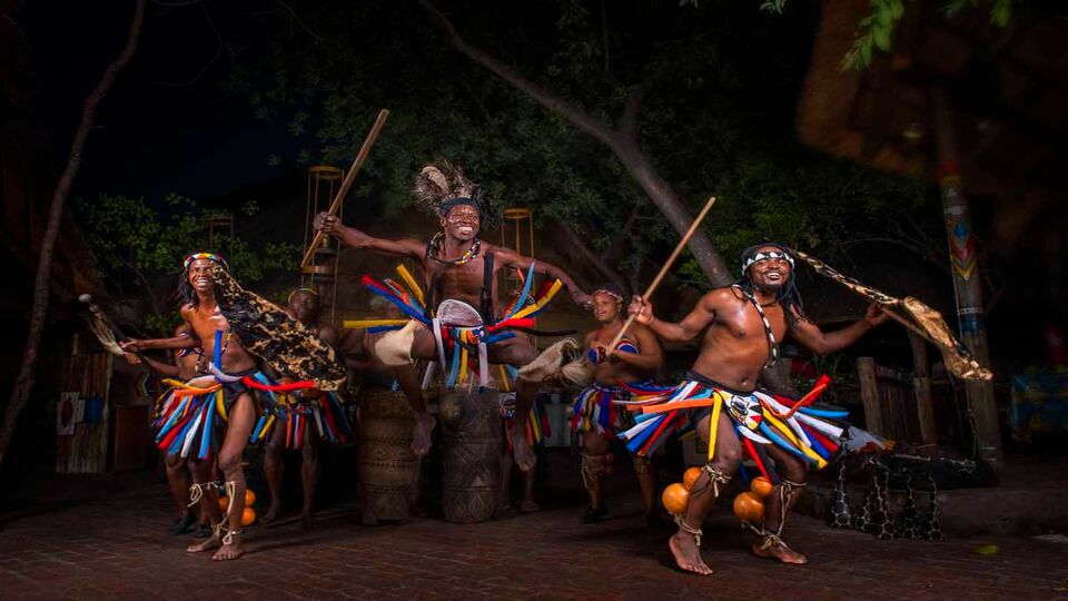 three men performing in traditional dress at the drum show