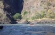 The Zambezi with a raft in the distance in front of sheer cliffs