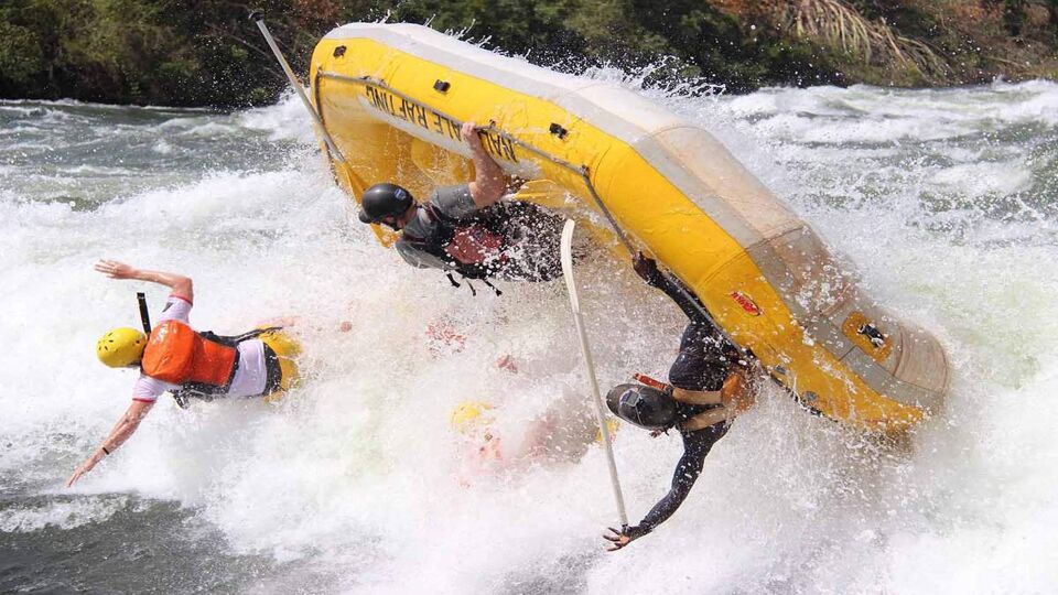 People falling out of the raft into the white water