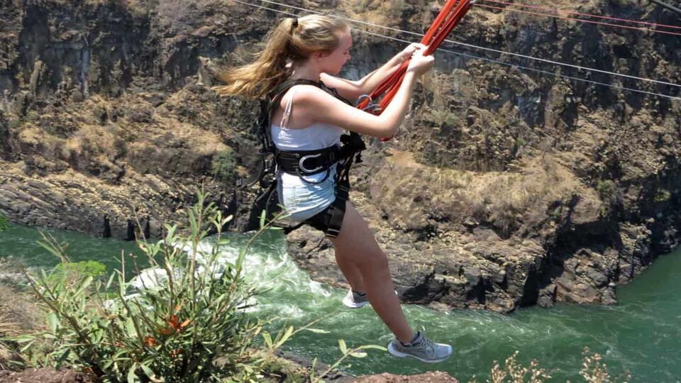 Blonde girl mid-action on the zip-line across the Zambezi