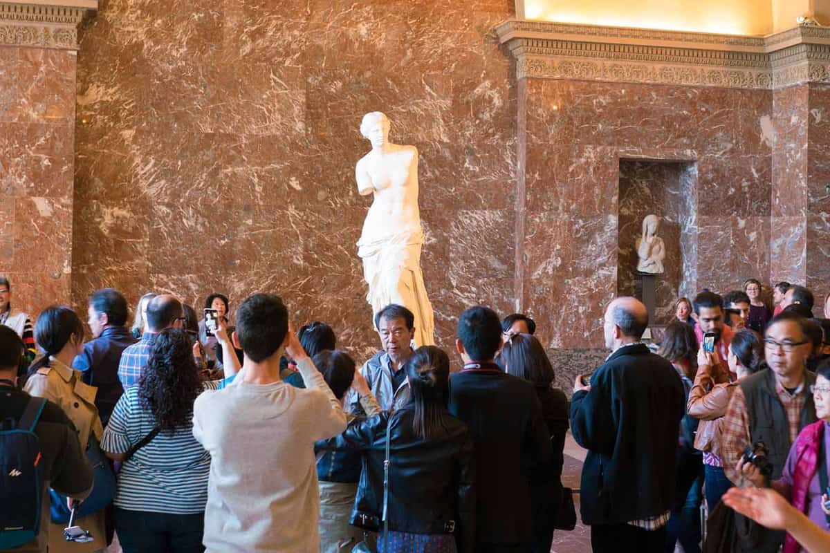 Tourists visit The Venus de Milo statue at the Louvre Museum.