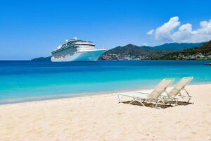 Iydllic golden back with two deck chairs and cruise ship in background