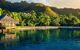 Villas in a tropical resort and with palm trees reflected in the ocean during sunset