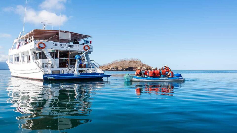 guests leaving their ship on asmall dinghy for an excursion