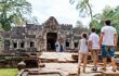 dad and two children looking at a dilapidated temple in Siem Reap