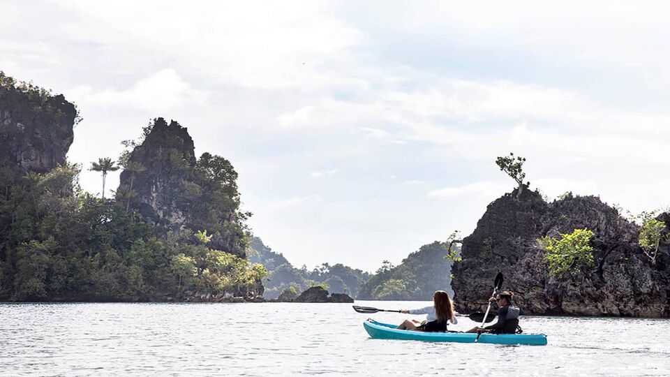 two women kayaking between islands