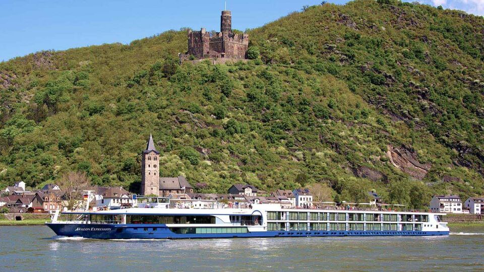 river cruising boat passing a castle on the hill