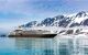 Cruise liner in front of snow-capped cliffs