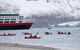 cruise passengers kayaking off the back of a cruise liner in the Svalbard archipelago