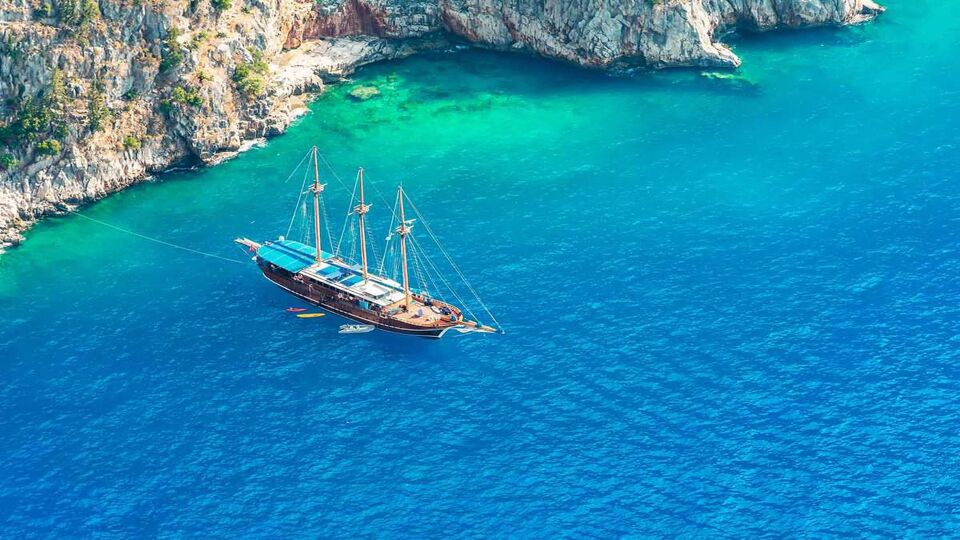 Aerial drone view of beautiful wooden sailboat in deep blue sea of Butterfly Valley, Fethiye,Turkey