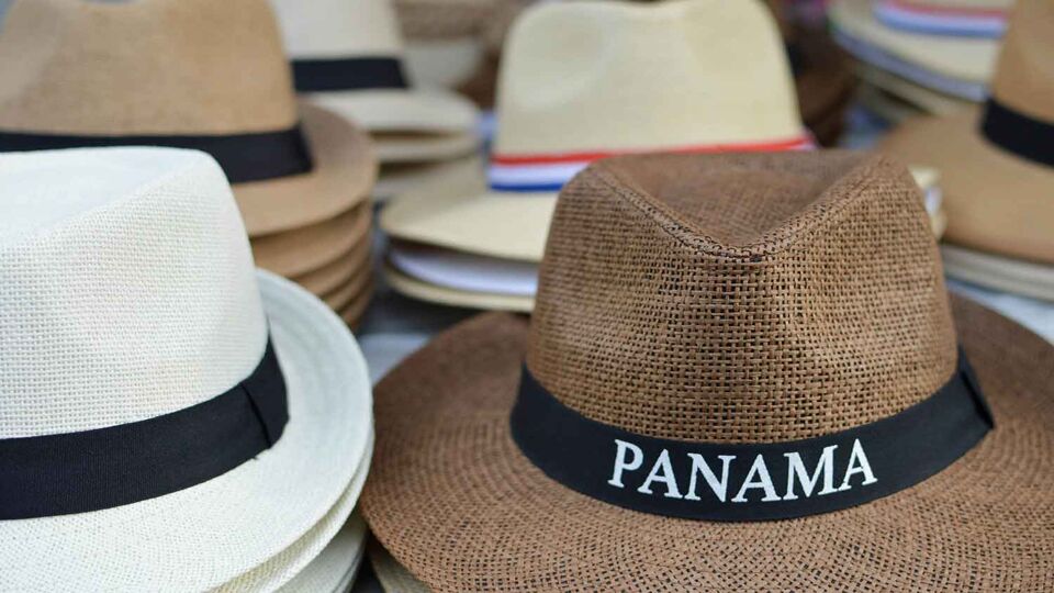 close up of piles of panama hats for sale on a market stall