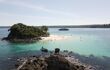 passengers walking the shallows around a tropical island