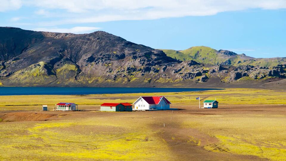 barren landscape with a few coloured huts on the plain