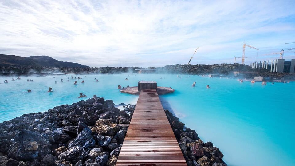 wooden pontoon jutting out in the steaming geothermal baths