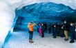 tour group in an ice cave with tour leader explaining how they are formed