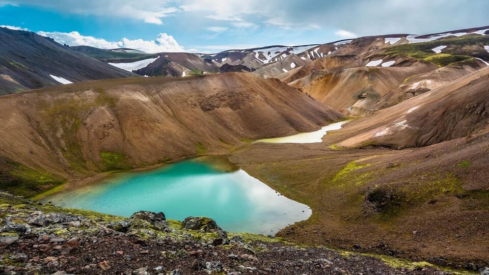 Emerald colored glacial lagoon in the midst of the surreal landscapes near Landmannalaugar along the Laugavegur hiking trail, Highlands of Iceland