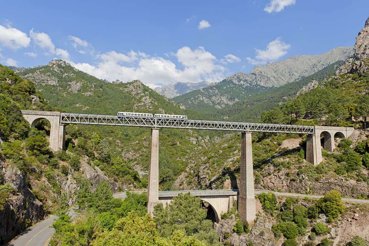 Train driving on large bridge and viaduct in Corsica, France
