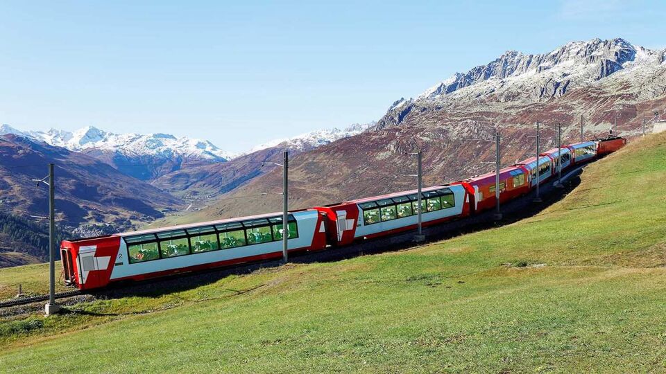 front view of Glacier Express train in summer alpine landscape