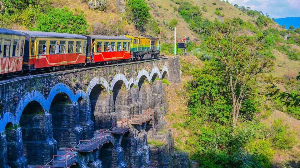 Kalka-Shimla Train passing over a stone bridge