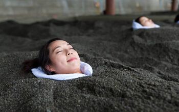 woman's face sticking out of hot black sand
