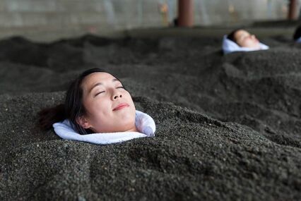 woman's face sticking out of hot black sand