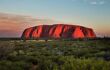 Landscape view of the red Uluru monolith at sunset