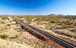 a railway track disappearing into the desert landscape