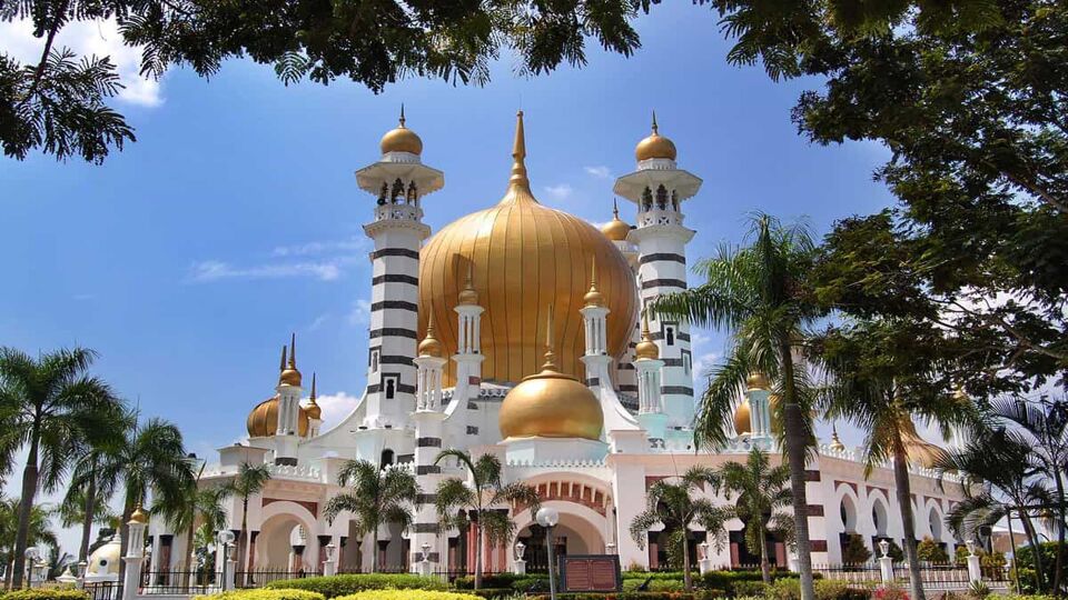 Exterior of the elaborate mosque with large golden dome in centre