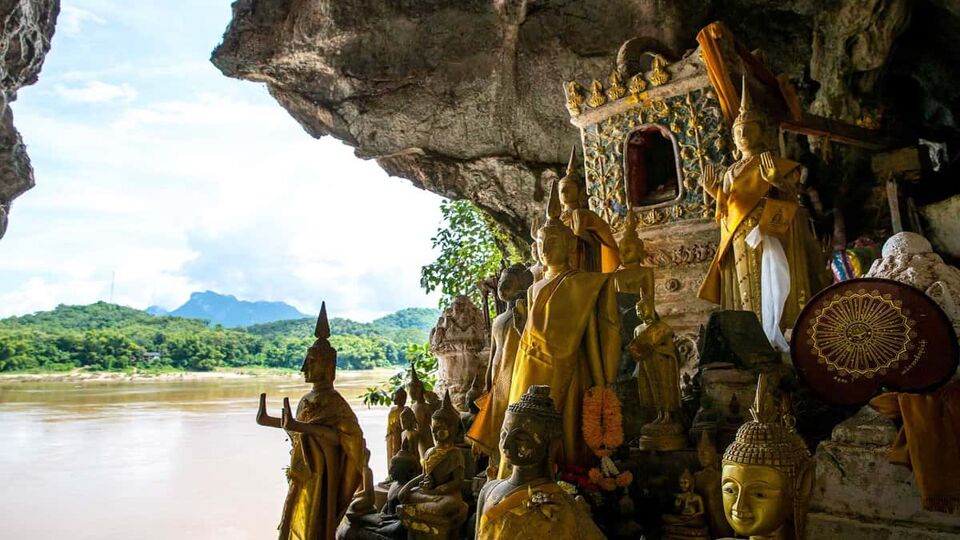 a shrine in a cave looking out onto the Mekong River